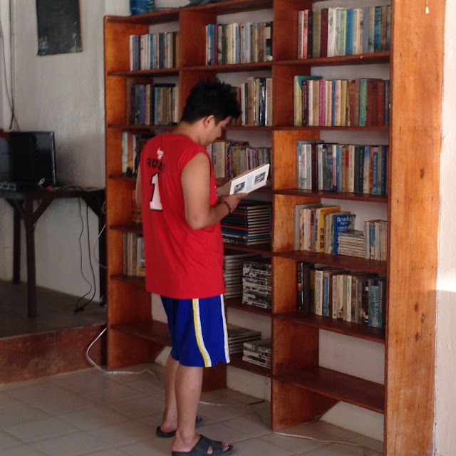Virgin Beach Resort in Cebu Daanbantayan Philippines Nathaniel checking the book collection at Virgin Beach Resort